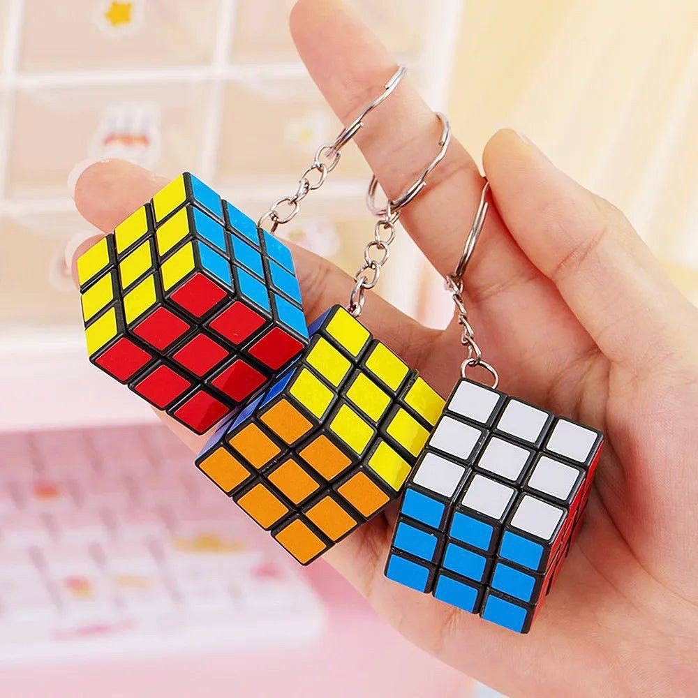 Rubiks Cube Keychain from a set of 10, featuring a mini 3x3 puzzle cube with red, blue, and white tiles. Ideal for travel and brain-boosting fun.
